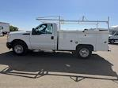 Ford F-250 utility service truck side view showing ladder rack and service body with compartments.