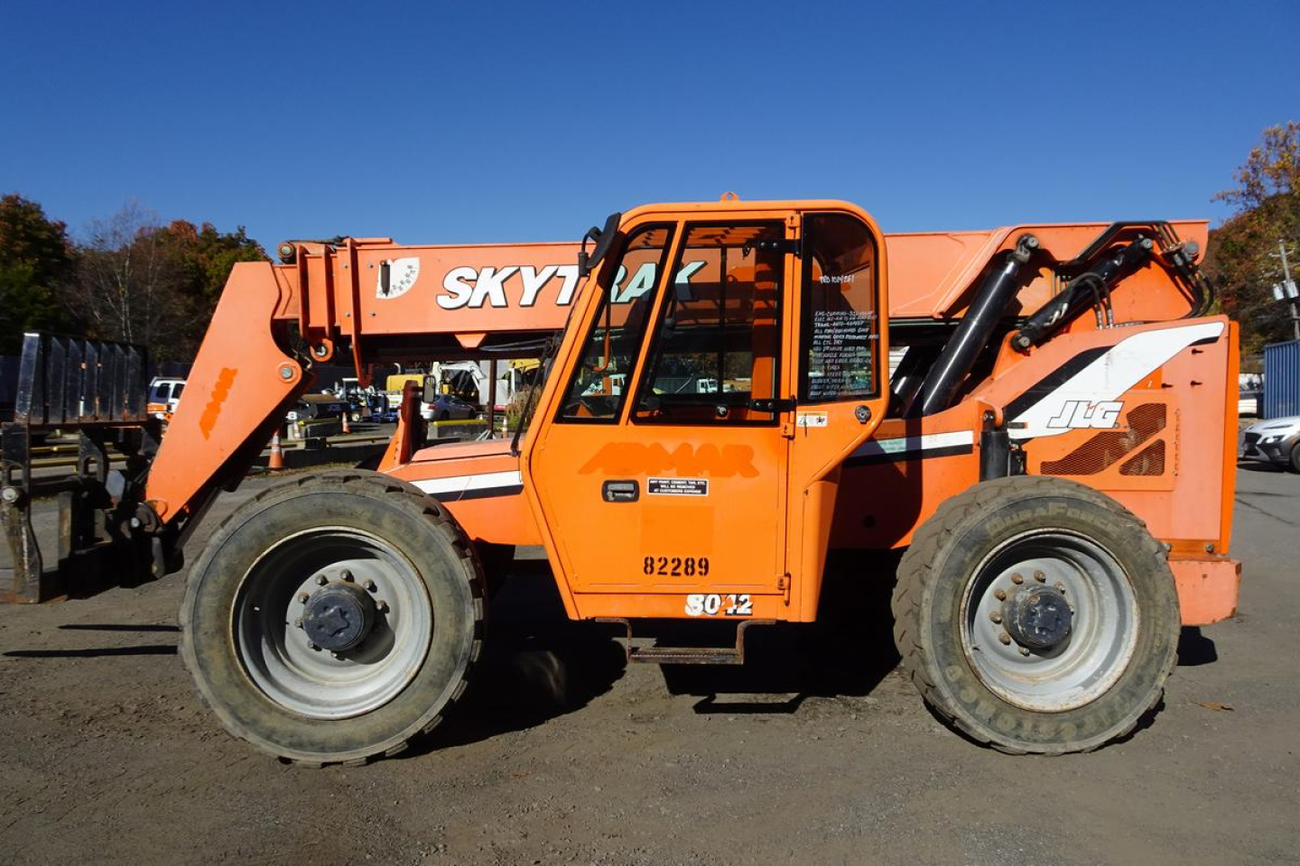 JLG 8042 telehandler in orange with extended boom and visible tires, side view.