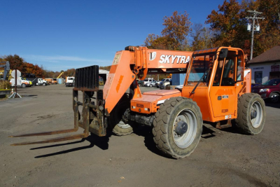 Orange JLG 8042 telescopic forklift in service bay with forks extended forward