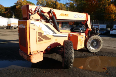 JLG Skytrak 8042 telescopic forklift in service position showing side and wheel details with orange paint and branding.