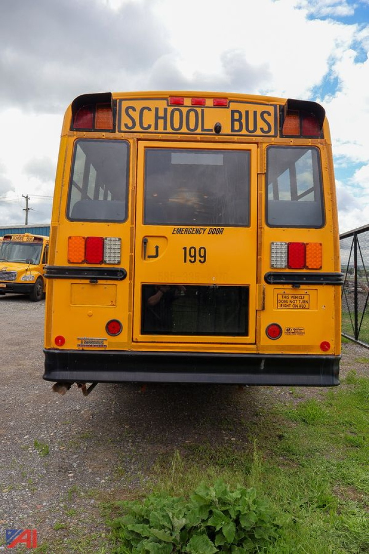 Rear view of a yellow Freightliner school bus with 'SCHOOL BUS' sign, emergency door, number 199, and warning labels.