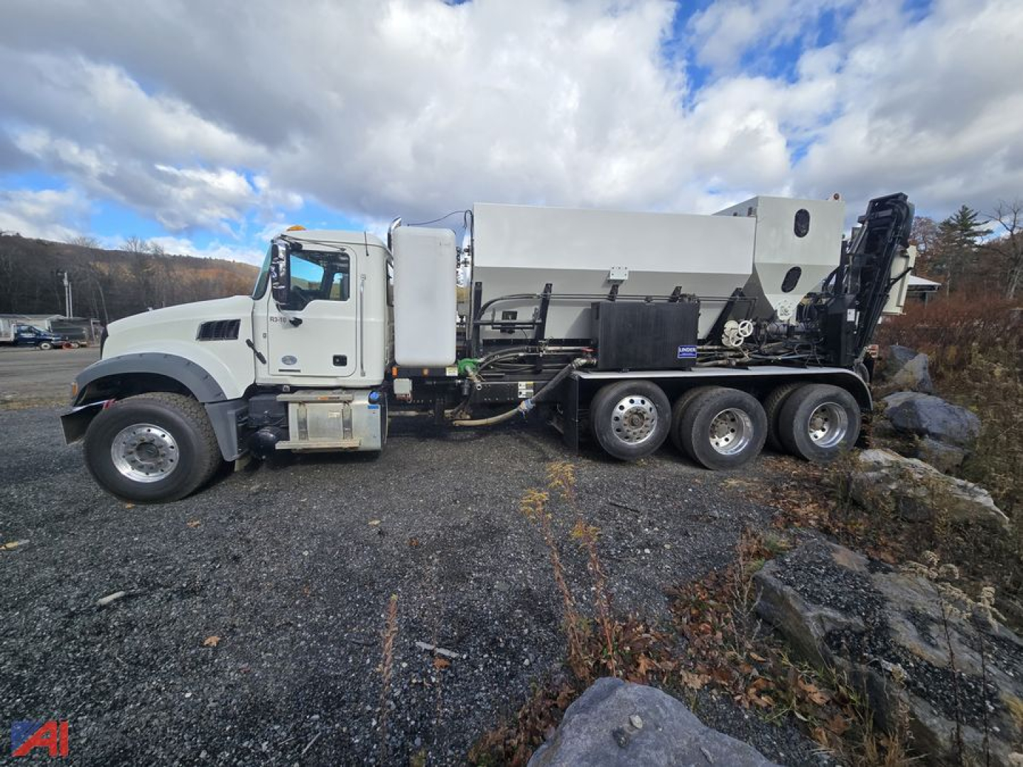 Mack Granite GR64F volumetric mixer truck side view showing mixer drum and hydraulic components.