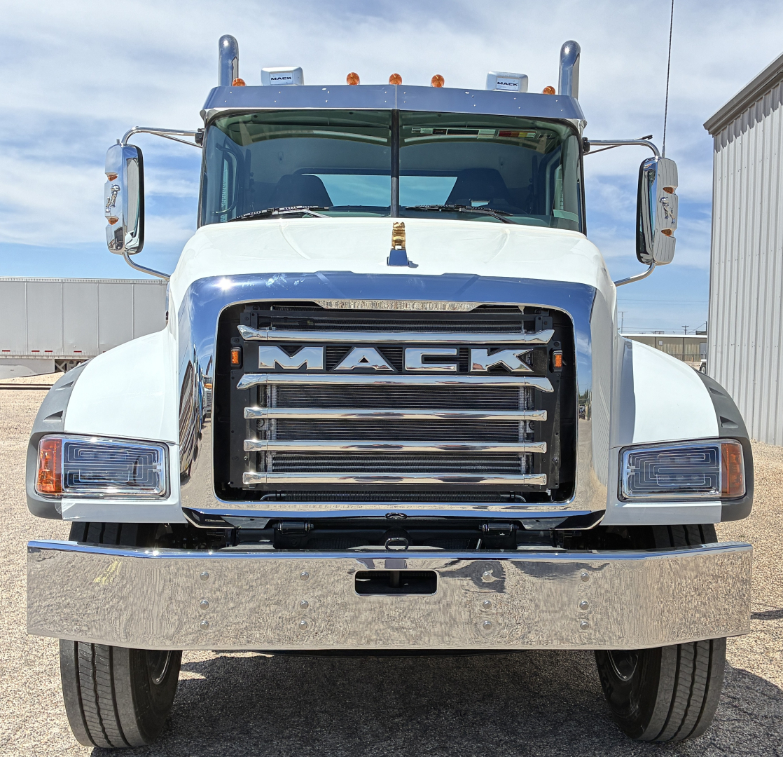 Front view of a white 2027 Mack GR64FT truck showing large chrome grille with 'MACK' lettering and bumper.