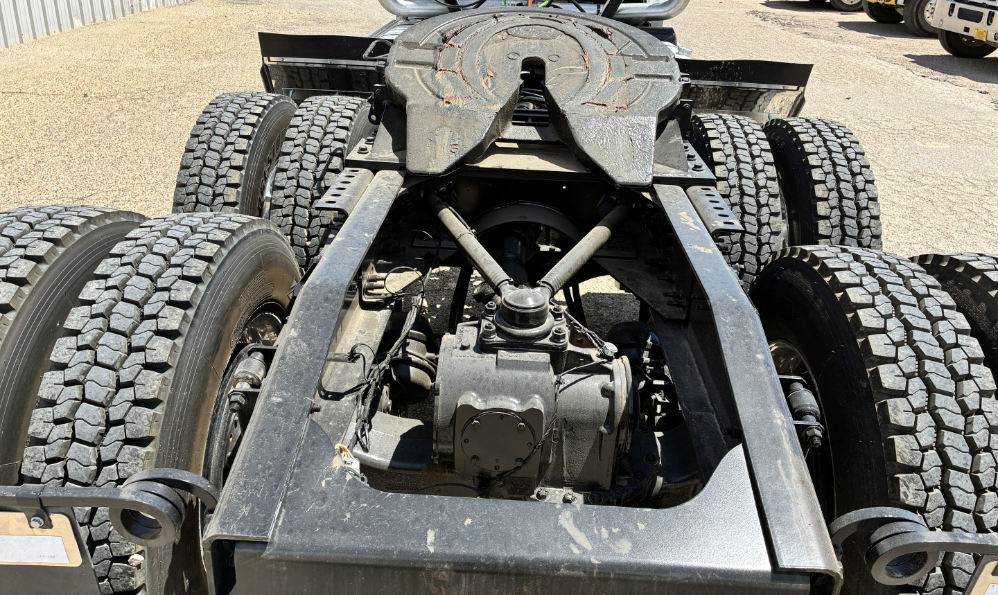 Mack GR64FT truck chassis rear view showing drivetrain suspension and fifth wheel mounting with dual rear axles and heavy-duty tires.