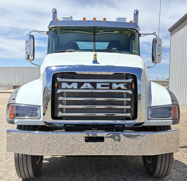 Front view of a white 2027 Mack GR64FT truck showing large chrome grille with 'MACK' lettering and bumper.