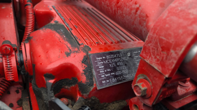 Kenworth T880 engine bay area with red exterior showing identification plate with model and serial details.