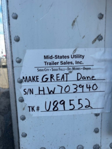 Mid-States Utility Trailer Sales label on a refrigerated trailer door with handwritten Make Great Dane and serial number HW703940.