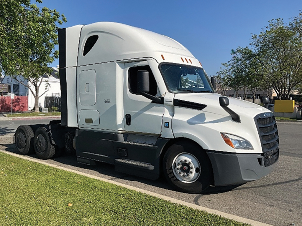 Truck cab showing clean white Freightliner Cascadia 126 sleeper with aerodynamic hood and dual rear axles.