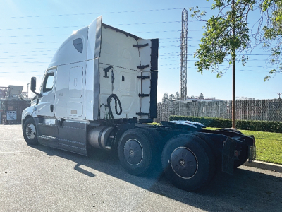 Freightliner Cascadia126 truck tractor side view showing sleeper cab and rear axles.