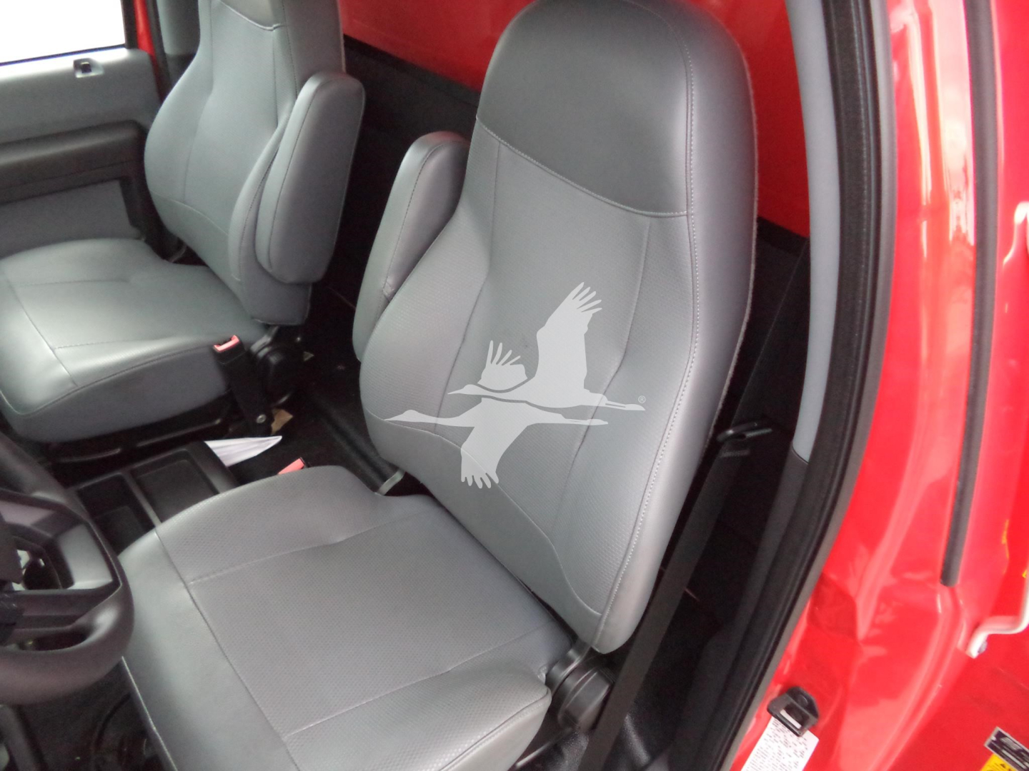 Ford F-650 interior showing front seats with gray leatherette upholstery and a large Winged Horse logo on the passenger seat.