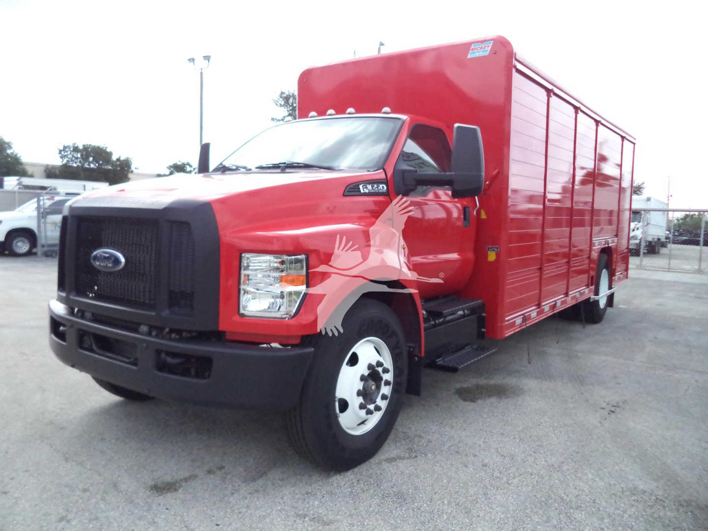 Red 2021 Ford F-650 service/utility truck side view showing large cargo box and black front grille.