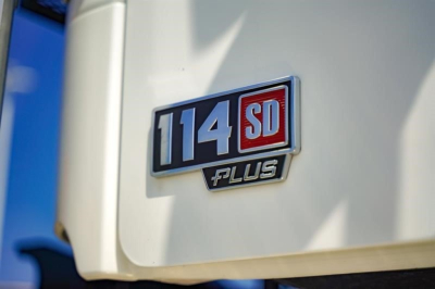 Truck badge showing 114 SD Plus emblem on a Freightliner cab exterior