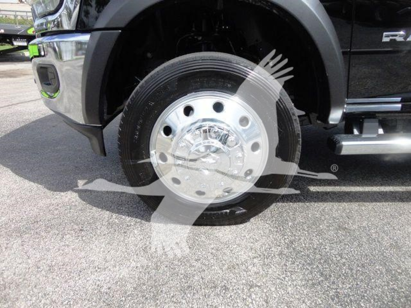 Truck front wheel showing silver steel hubcap and Black tire; Ram 4500 SLT badge visible on exterior; partial front bumper and step rail in view.