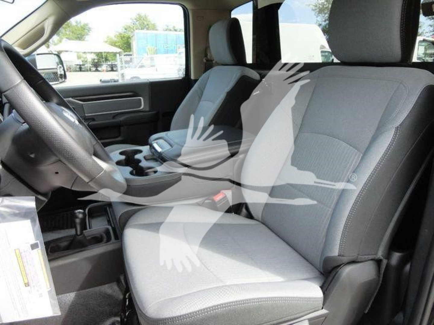 Ram pickup truck interior showing front seats and dashboard as seen from the driver’s side.
