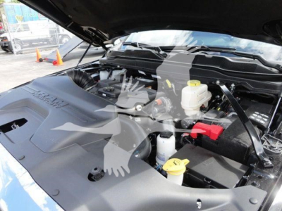 Ram 4500 engine bay view with hydraulic fluids and battery visible; yellow caps for brake fluid and coolant; red battery terminal cover.