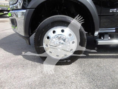 Truck front wheel showing silver steel hubcap and Black tire; Ram 4500 SLT badge visible on exterior; partial front bumper and step rail in view.