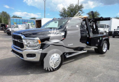 2024 Ram 4500 SLT tow truck with winch, black cab, chrome bumper, side step, dual rear wheels, and equipment on flatbed; visible text on grille RAM badge.
