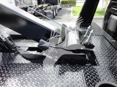 Winch mounting assembly on a flatbed truck with hydraulic winch drum and cables visible, mounted on diamond plate bed.