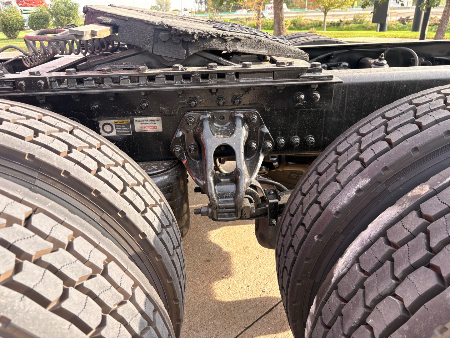 Kenworth T680 chassis showing rear dual axles and fifth wheel assembly with visible suspension components and tires.