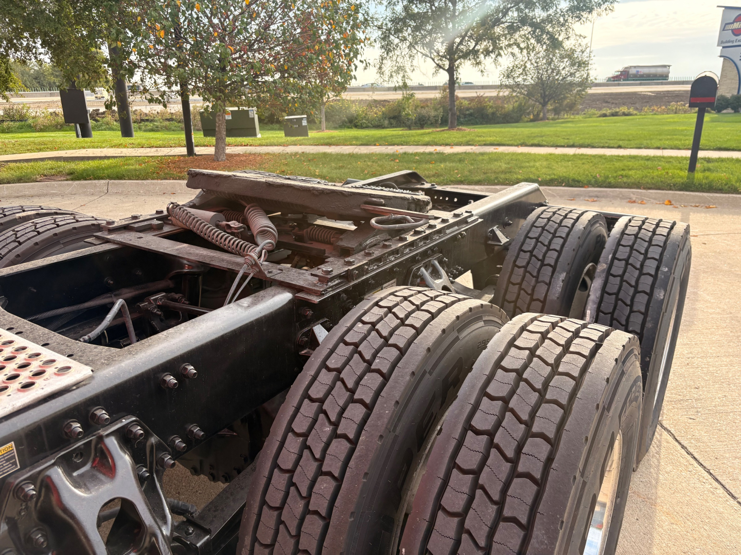 Kenworth truck chassis view showing multiple rear axles and tires. No labels readable on components. The image focuses on the undercarriage and wheel assembly without visible serials or fluid labels.