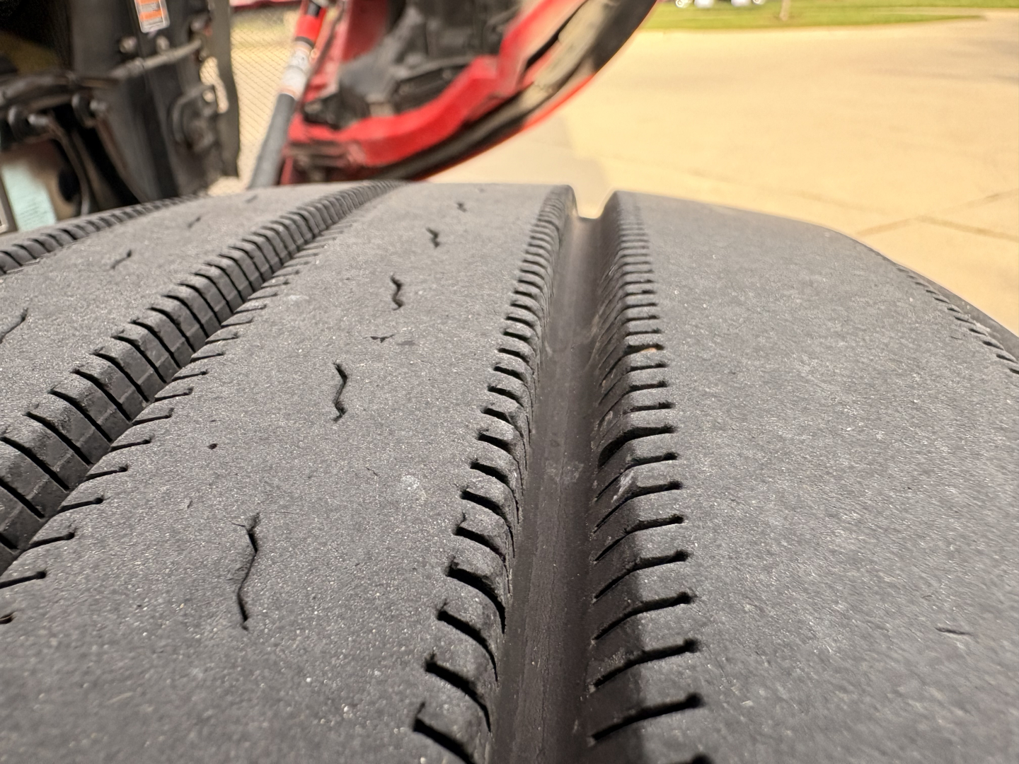 Tire tread close-up on Kenworth T680 truck wheel well, showing dual tire profile and road grime.