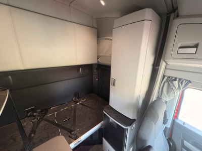 Kenworth T680 truck interior side sleeper area showing storage cabinet and seating mount.