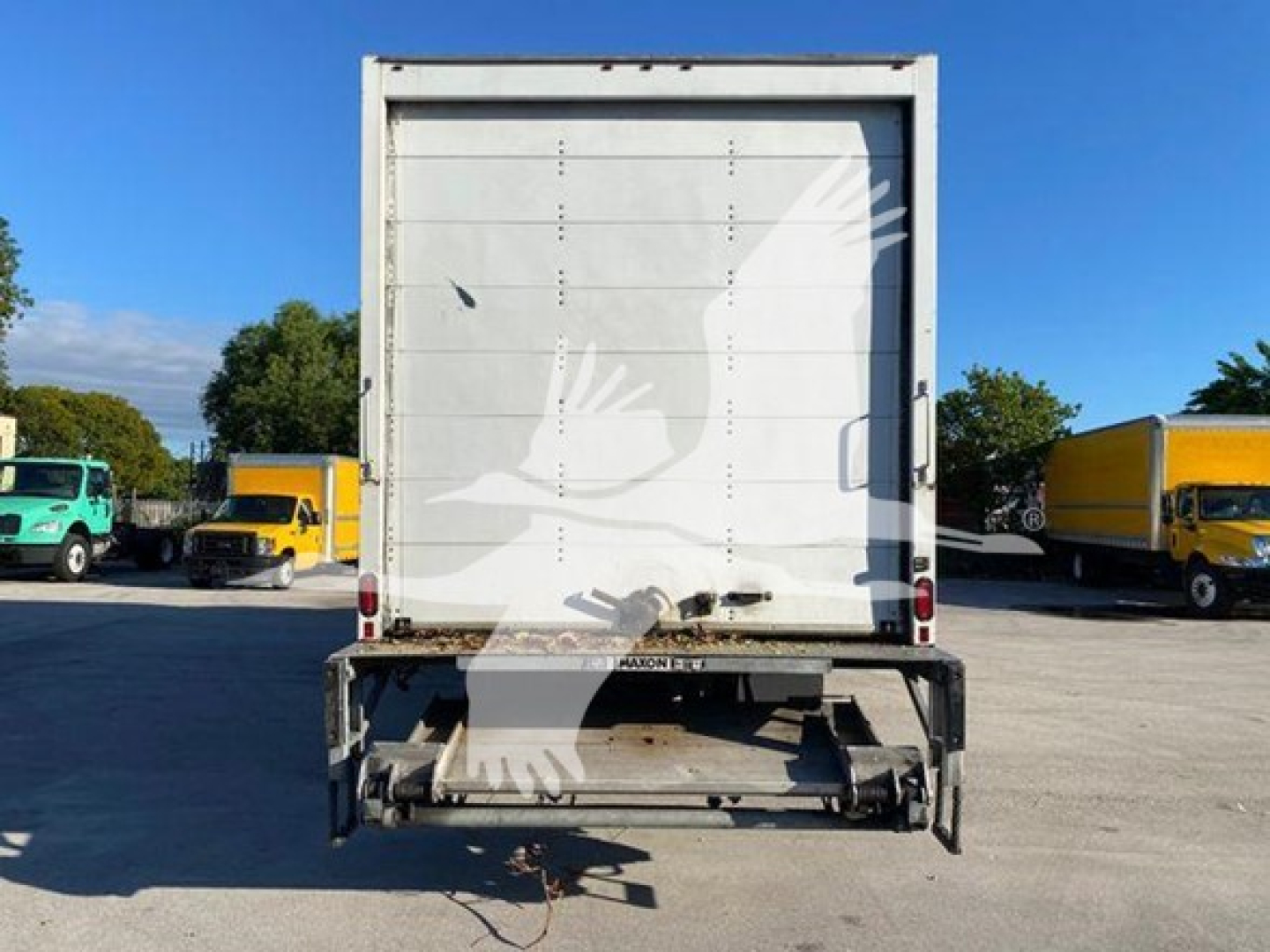 Rear view of a 2020 International MV box truck showing back doors, liftgate, and cargo area.