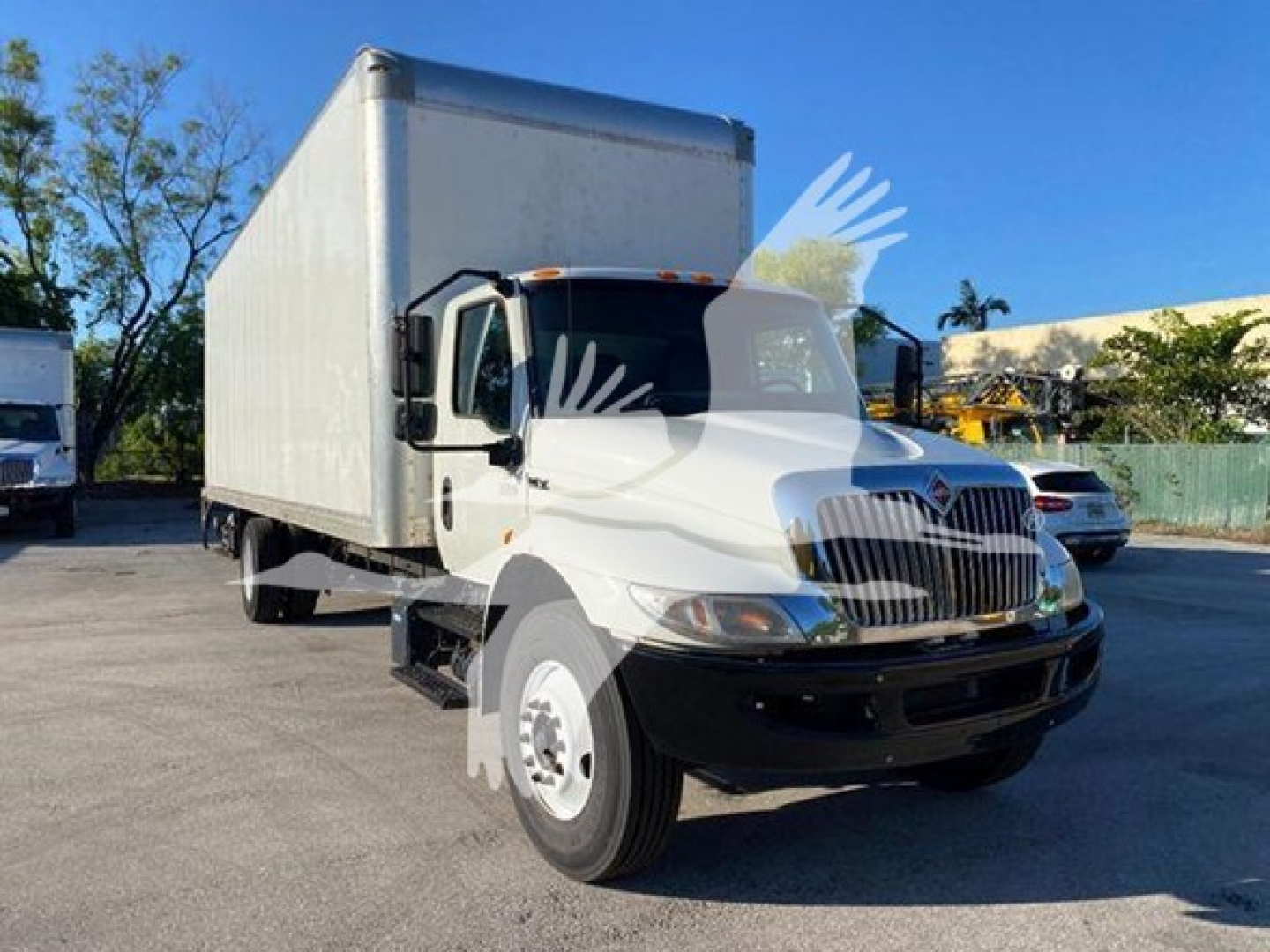 Truck cab and box truck with white cab and large box, International logo on grille, front view at slight angle.