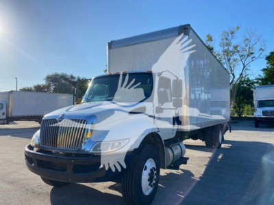 Box truck with white cab and box body, International heavy-duty truck, front grille, dual rear wheels visible, no visible text on side panels.