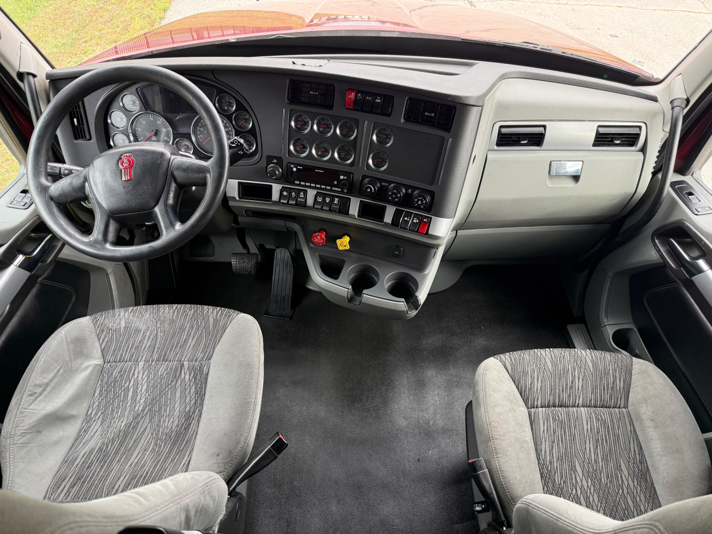 Kenworth T680 interior dashboard and driver seat view showing steering wheel and instrument cluster.