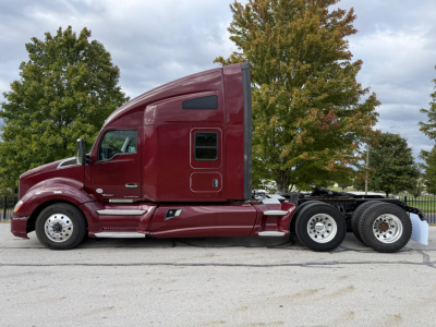 Kenworth T680 conventional sleeper tractor in maroon showing cab side profile and rear wheels.