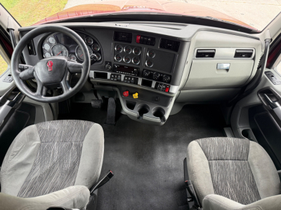 Kenworth T680 interior dashboard and driver seat view showing steering wheel and instrument cluster.