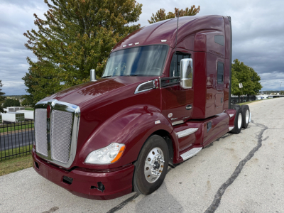 Kenworth T680 tractor in maroon showing aerodynamic hood and chrome grille with sleeper cab. VIN plate not visible; side mirrors and wheels visible.