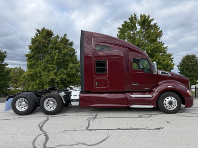 Kenworth T680 semi-truck side profile showing maroon cab and sleeper, with dual rear axles and chrome steps.