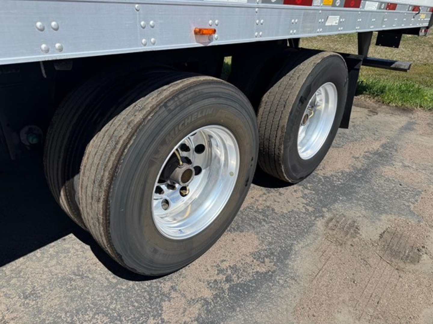 Dual rear trailer wheels on a Utility 3000R trailer showing Michelin tires and silver rims with black rubber treads.
