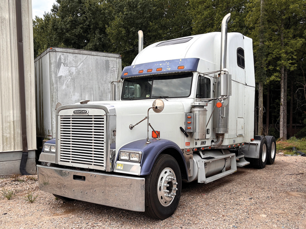 Truck: 2000 Freightliner FLD13264T Classic XL conventional sleeper showing front grille, bumper, dual stacks, and side fuel tank.