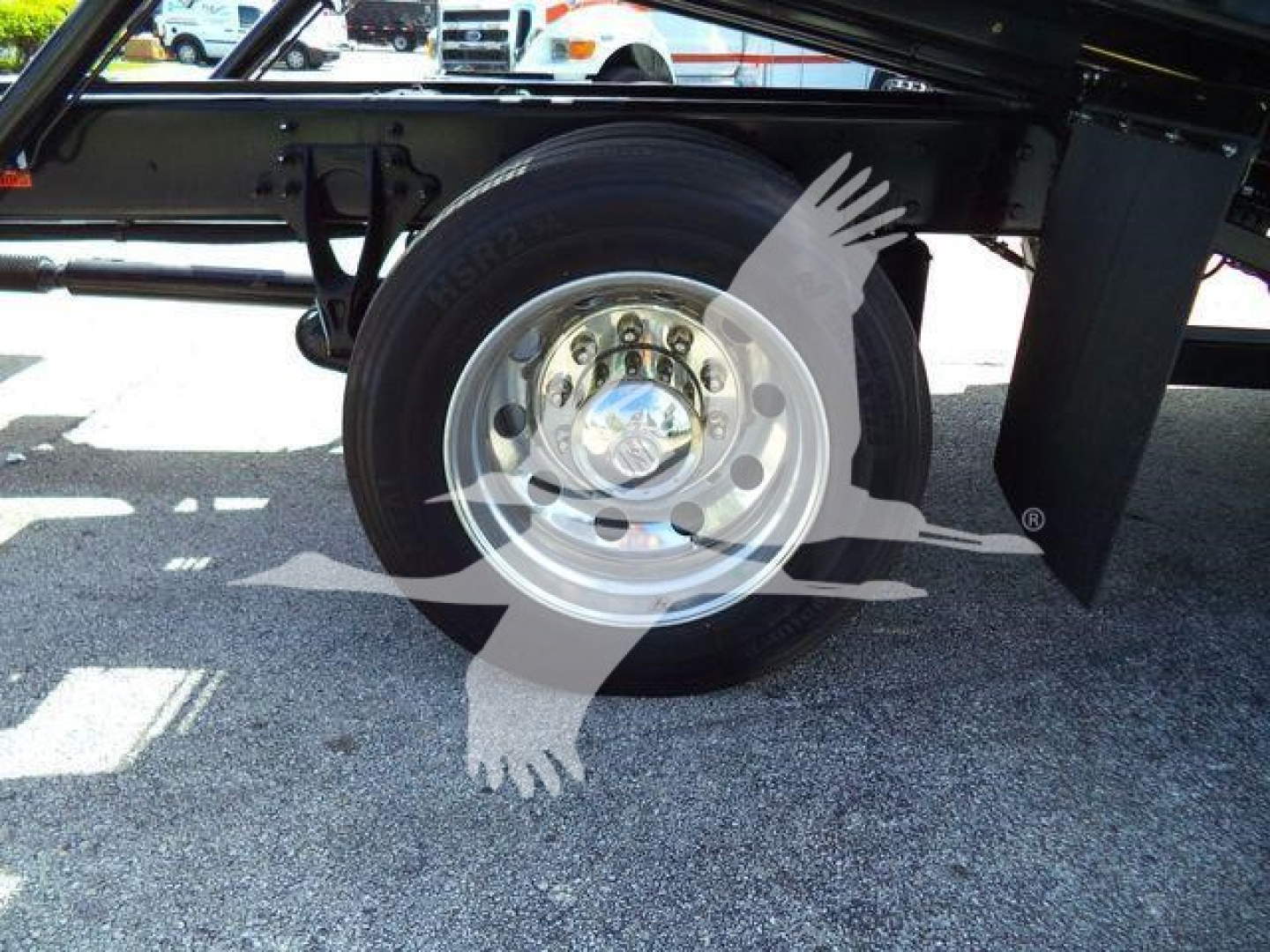 Truck axle/wheel assembly showing a single tire mounted on a polished steel rim under the chassis of a 2027 International MV rollback truck.