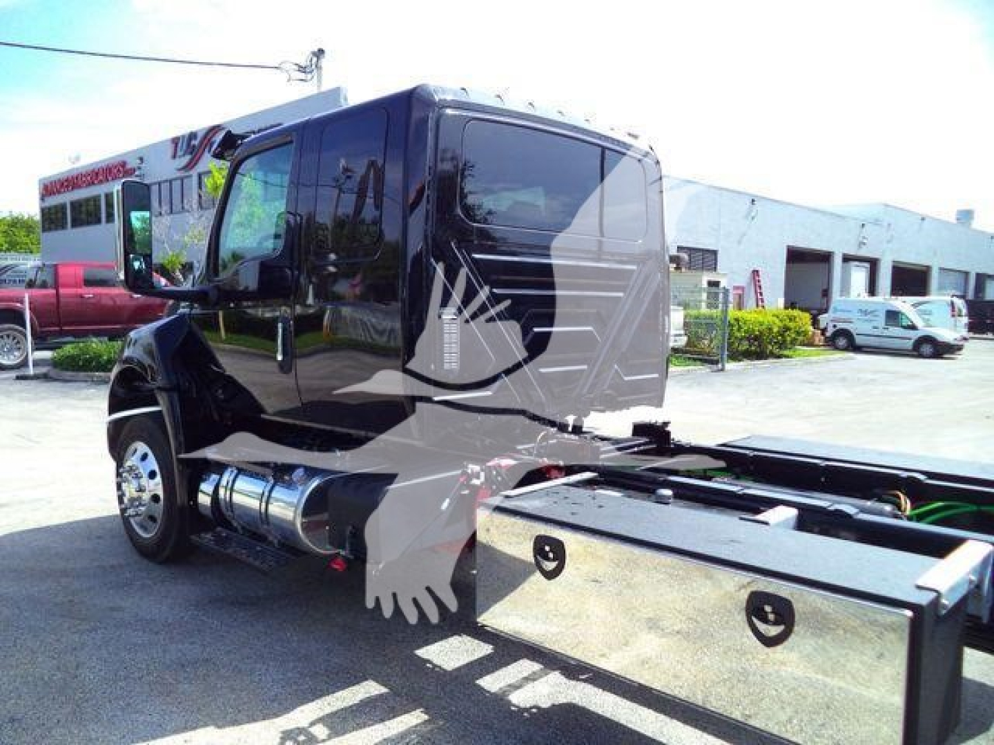 Truck cab of a 2027 International MV rollback showing black exterior and chrome fuel tanks with side view