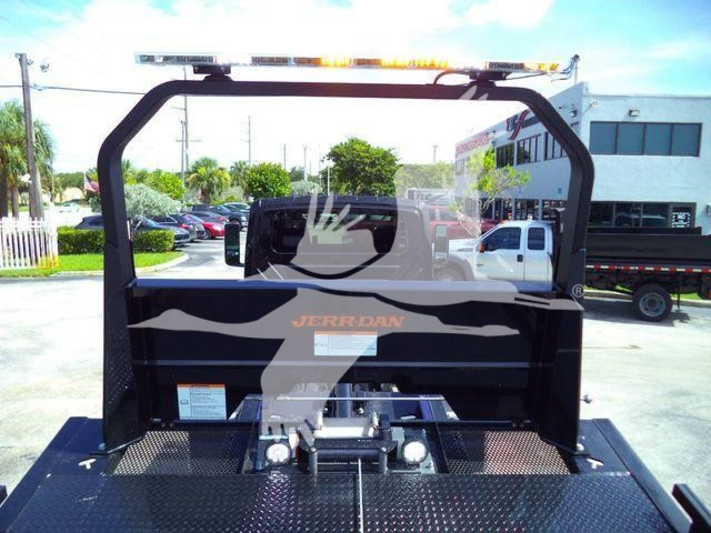 Truck bed with winch and frame seen from tailgate area; back of cab shows JERRDAN logo.