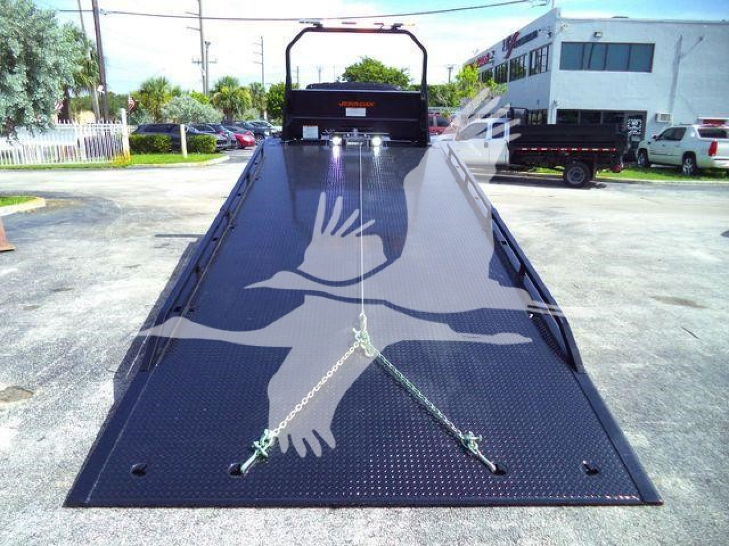 Tow truck rollback flatbed with black diamond-plate surface showing tiedown anchors and a rear ramp, MV607EXCABBLK stock number.
