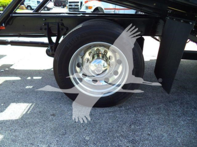 Truck axle/wheel assembly showing a single tire mounted on a polished steel rim under the chassis of a 2027 International MV rollback truck.