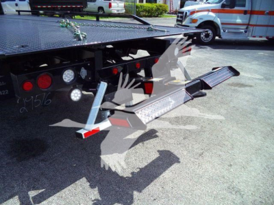 Flatbed tow truck wheel-lift/dolly with loading ramps extended showing platforms and safety lights.