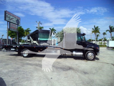 2027 International MV rollback truck on flatbed with stock number MV607EXCABBLK visible in a dealership lot.