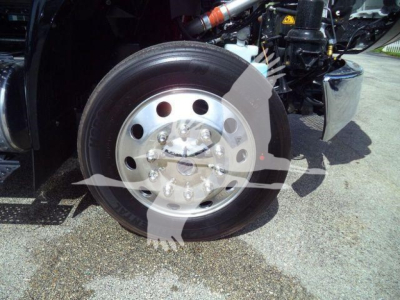 Truck wheel with polished metal hubcap and tire, front axle area of a 2027 International MV rollback truck