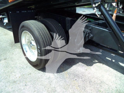 Trucks undercarriage showing rear dual wheels and suspension of a 2027 International MV rollback truck with black chassis