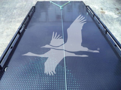 Image showing a black steel rollback truck bed with a large white winged seagull logo. No visible text other than the logo.  