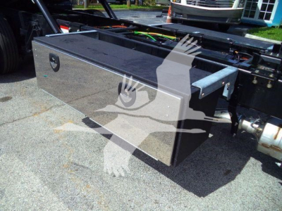 Metal toolbox with reflective surface mounted on a truck chassis showing a rectangular aluminum storage box with latch and mounting rails.