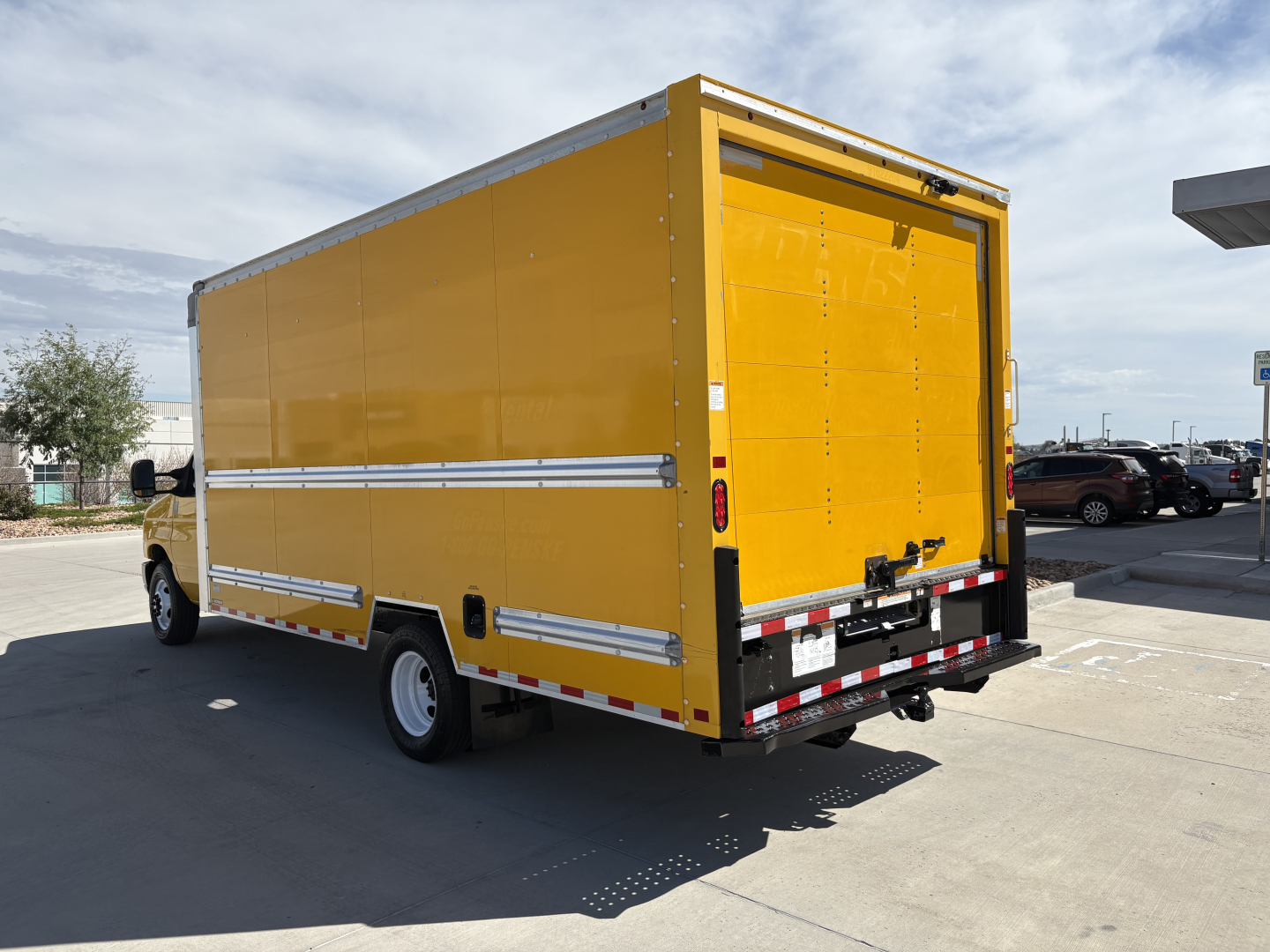 Ford E350 box truck rear view showing yellow cargo box with rear double doors and reflective striping.