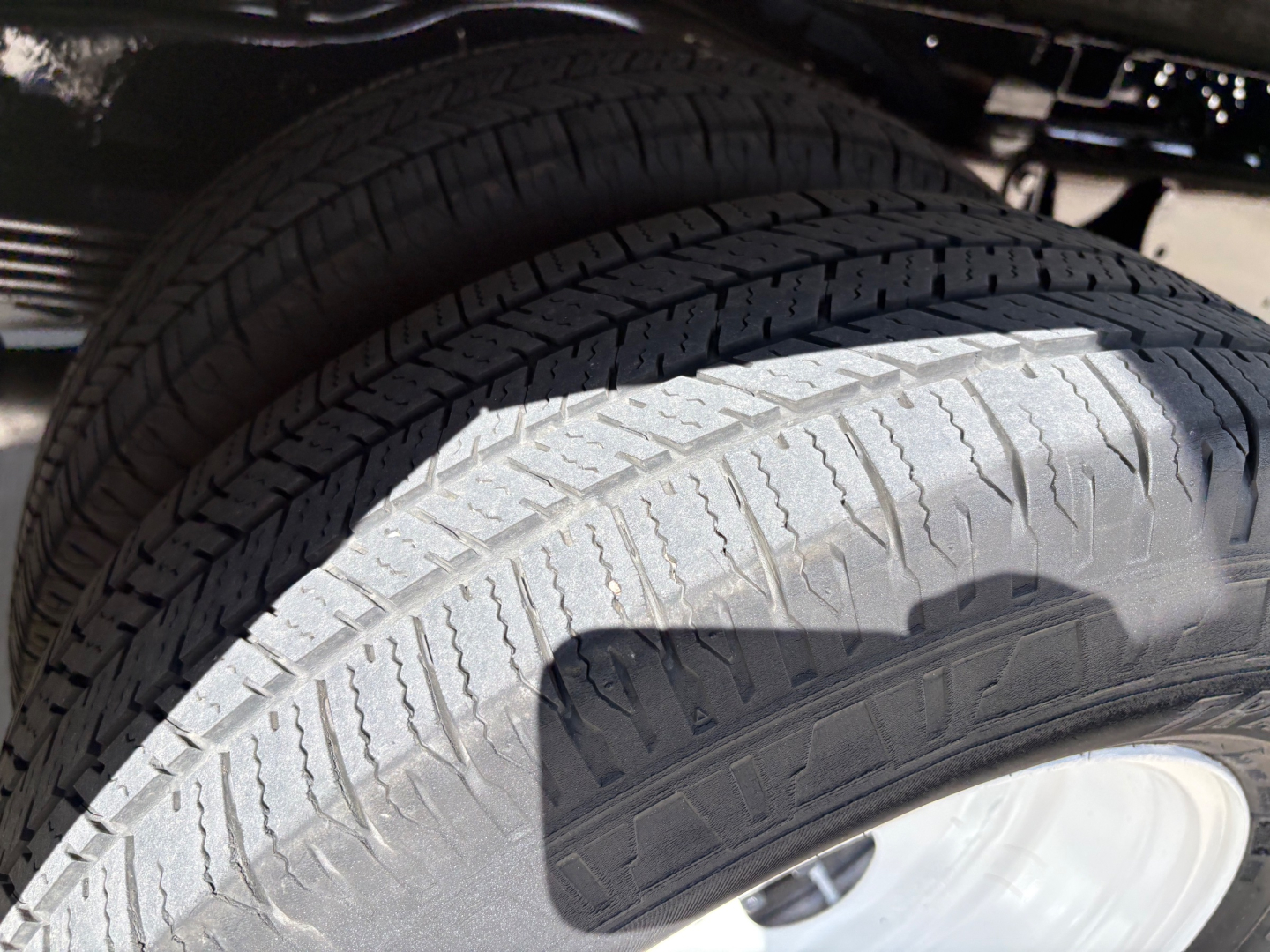 Dual front tires showing tread pattern and wheel, part of a Ford E350 chassis with wheel wells visible