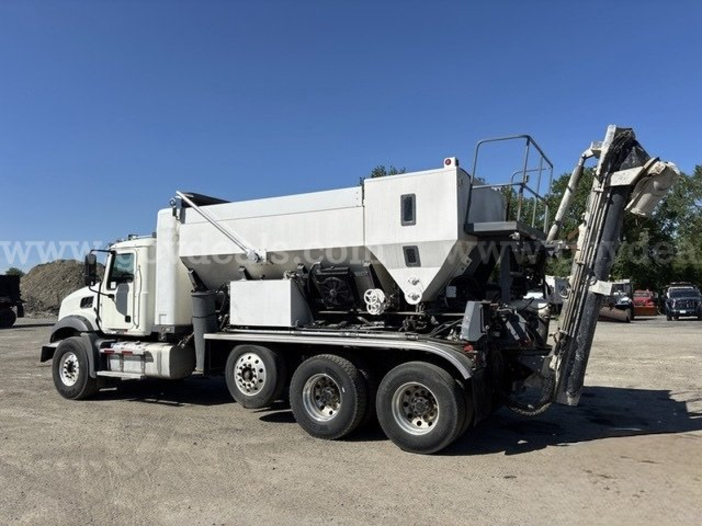 Freightliner mixer truck in-service showing concrete mixer and rear discharge chute with white cab and multi-axle chassis.
